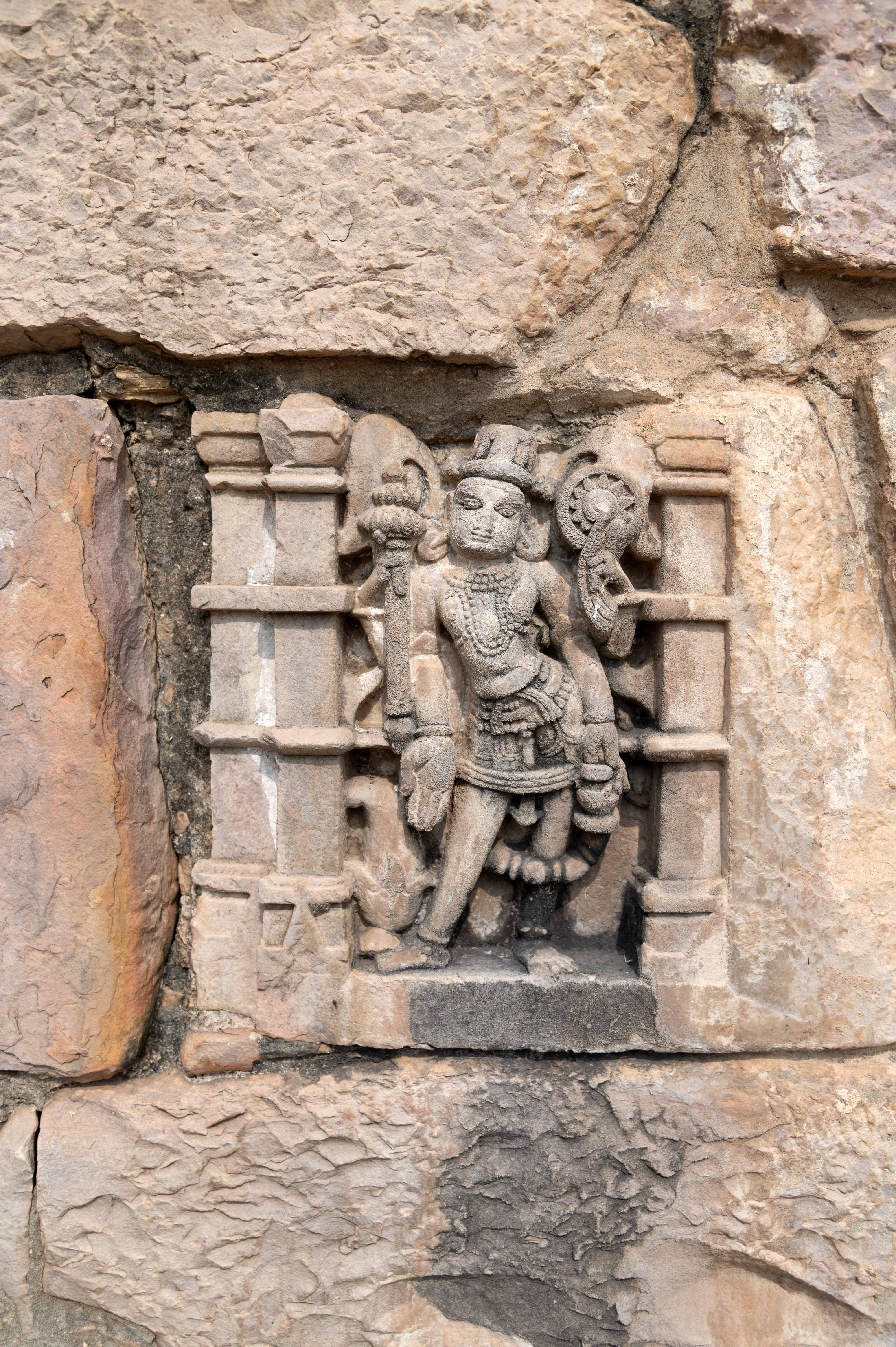 Image 12: Vishnu is depicted holding a shankha (conch) and a chakra (discus) in the upper arms and a gada (mace) and kamandalu (water pot) in the lower hands. In some of the sculptures, instead of holding a kamandalu, he is depicted with his lower hand in varada hasta (boon-giving gesture).