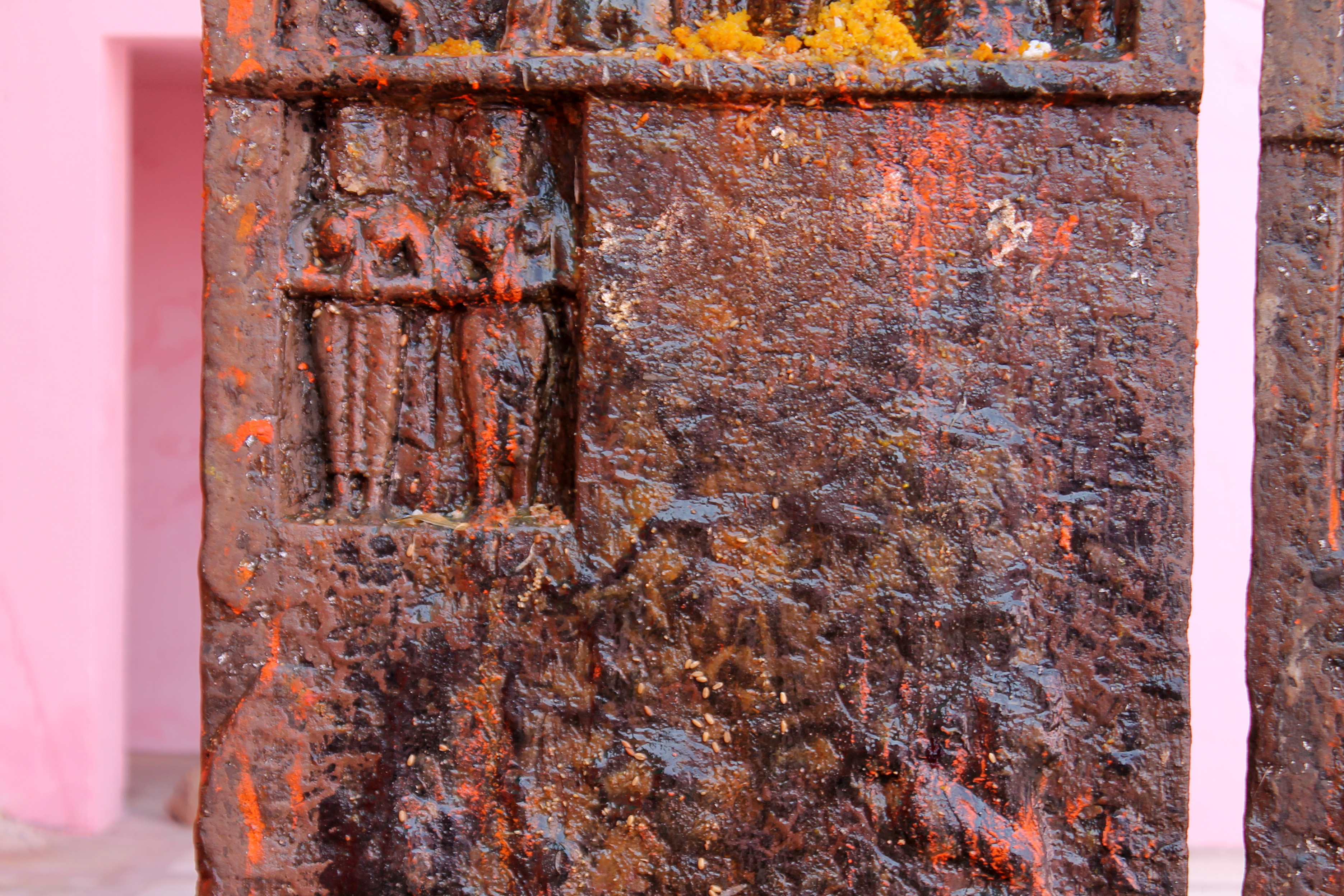  In the second small panel in the hero stone, positioned just below the row depicting the hero, stand two female figures with folded hands in namaskar mudra (salutation gesture). Their upright posture is emphasized by their drapery, consisting of a decorated lower garment. The female figures represent celestial damsels believed to have arrived to escort the hero to heaven.