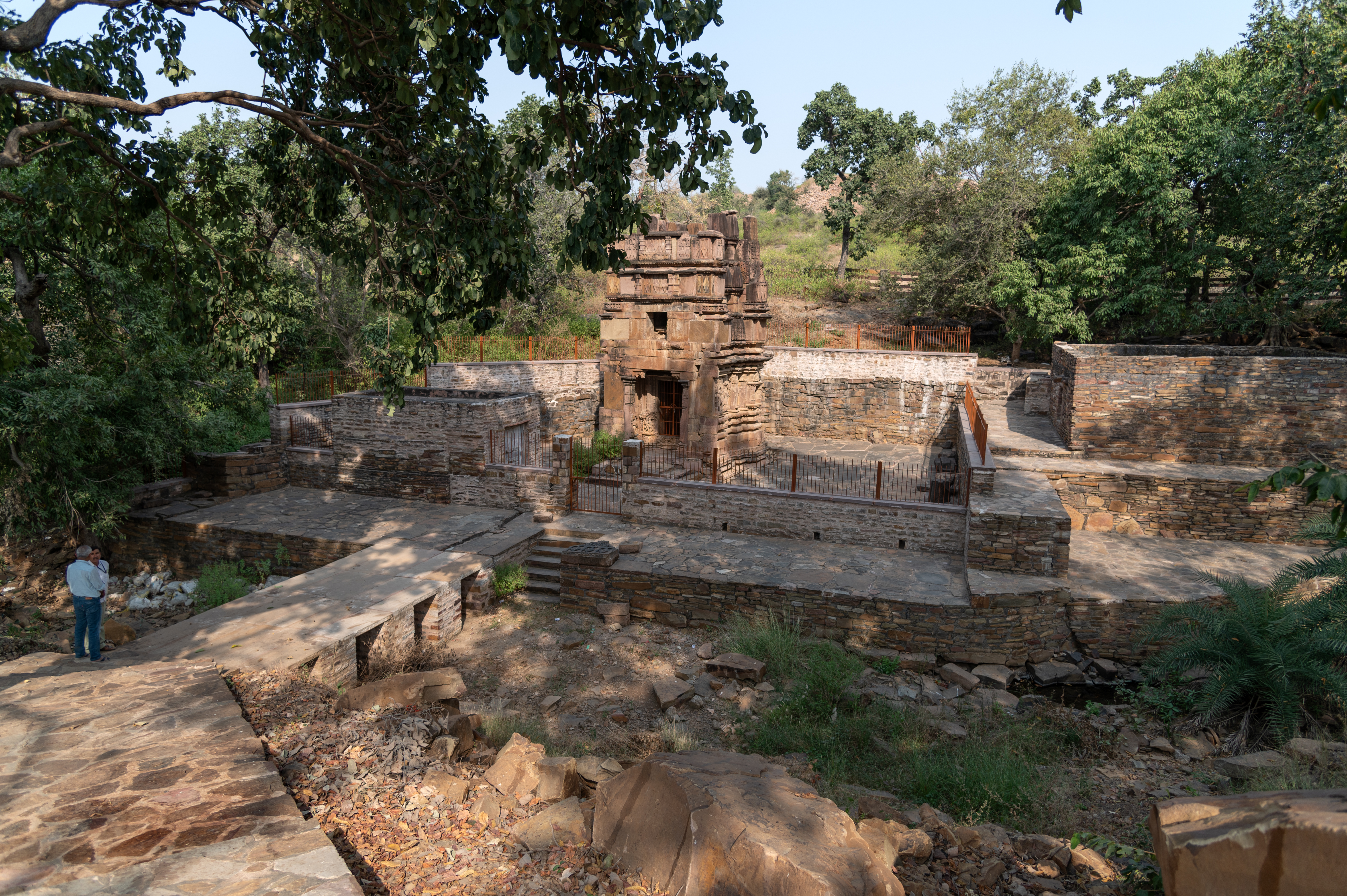 Image 1: The Kaner-ki-Putli Temple is situated near a water stream in the locality known as Kharen, with a boundary wall and a pathway guiding visitors to the temple.