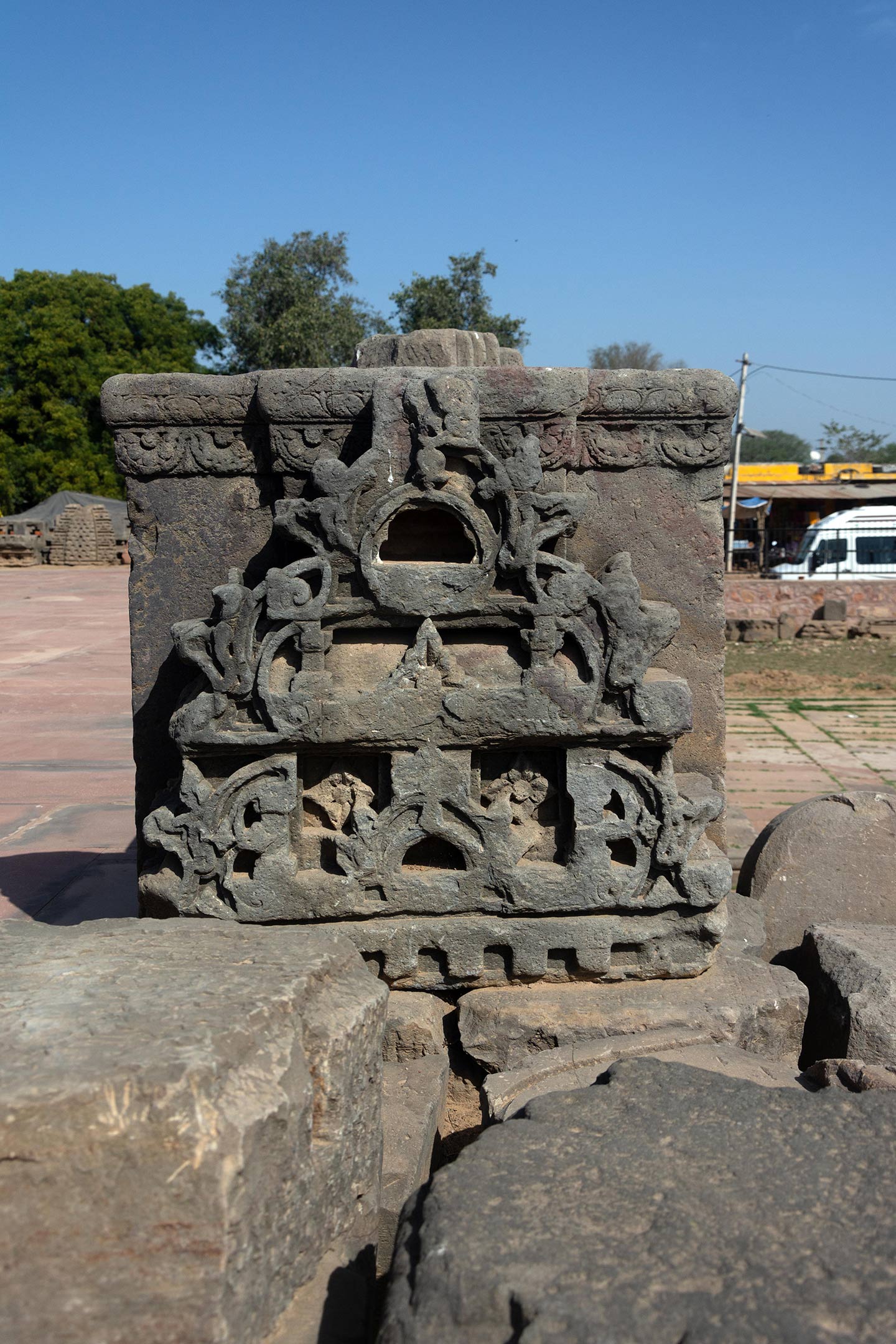 Broken debris from the original temple was assembled on the adhisthana landing of the first set of steps. The temple repeats the split gavaksha motif throughout. Hindu temples frequently display this motif.