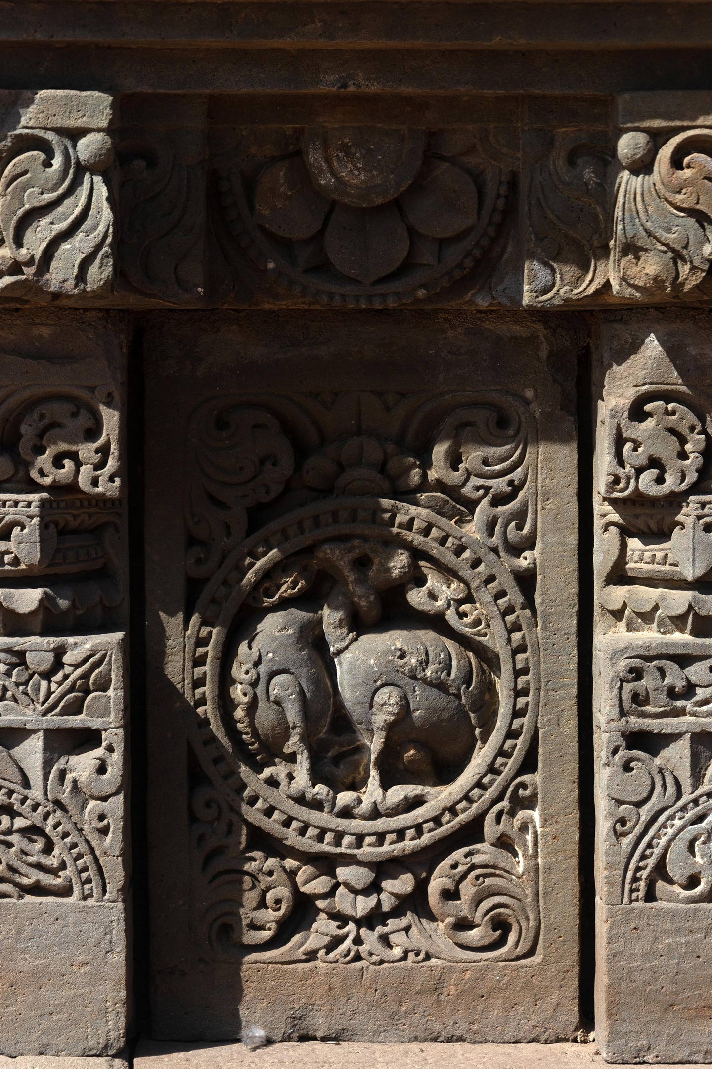 This plaque features two birds, likely hamsas (swans), with their necks entwined. Squat pillars, boasting a square base, an octagonal shaft, and a square capital, divide the plaques. The pillars are decorated with ardha padma (half lotus) and kalpa lata (creeper) motifs.