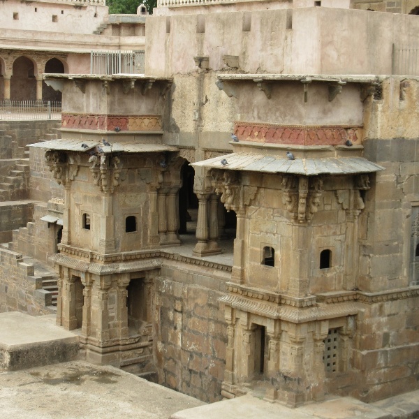 Image 5: The room is colonnaded and spacious, complete with cusped arches. Two flights of stairs on both ends allow entry into the 'palace'. The arcade is four-sided with pointed arches. It is also known as the Summer Palace. Small jalis are present on the windows.