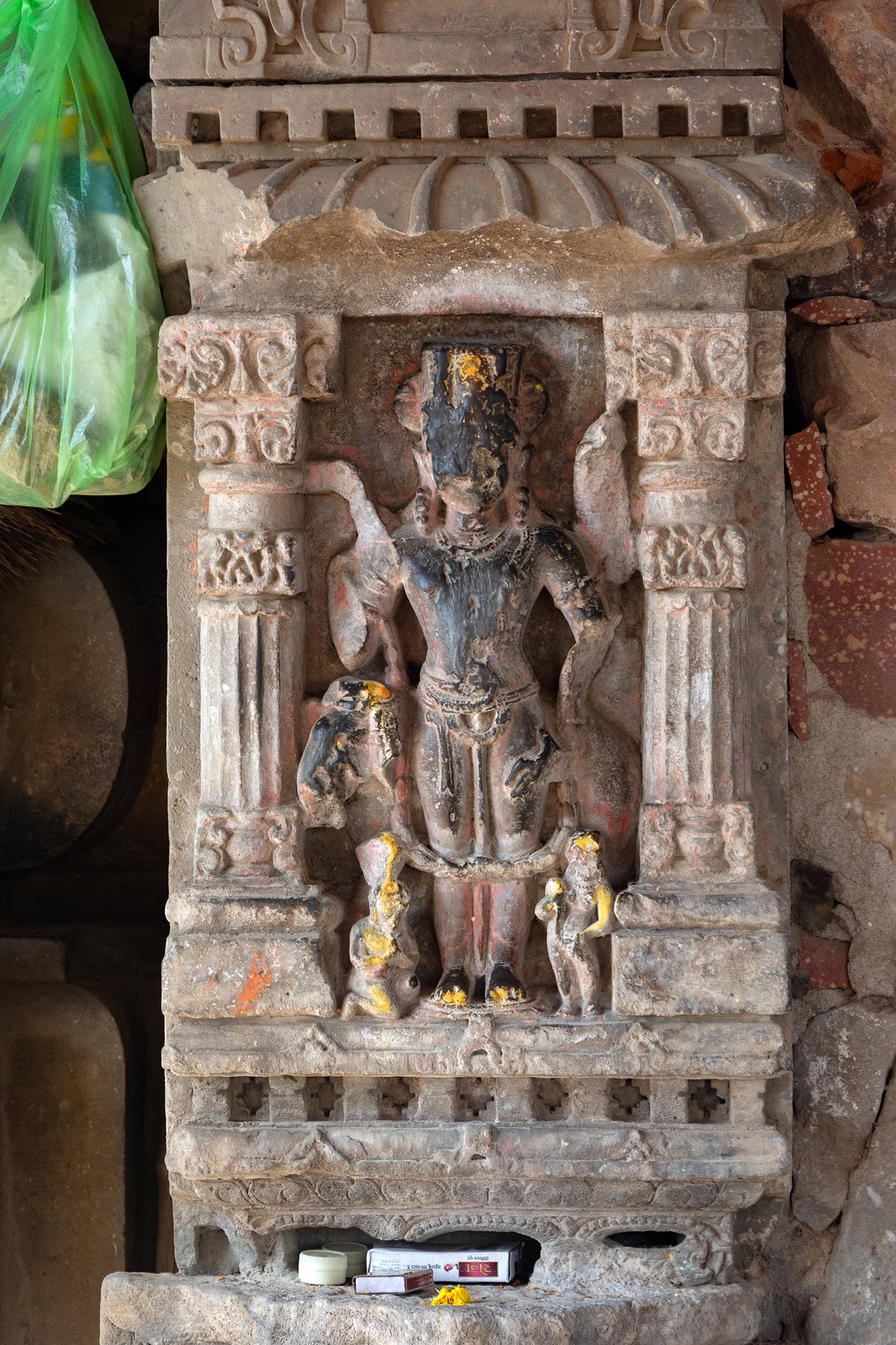 Image 13: This panel may be a depiction of Lord Indra, who is king of the devas (celestial beings) and ruler of the swarga (heavenly realm). As the dikpala (guardian of directions) of the east, Indra faces eastward in this panel. The central figure is a crowned male standing in samapada mudra (feet equally balanced) and carrying a vajra (thunderbolt). An elephant is standing behind (its head visible on the left), which could be the white elephant Airavata, the mount of Lord Indra.